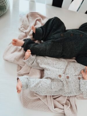 Newborn twins sleeping in a cot for breastfeeding blog post
